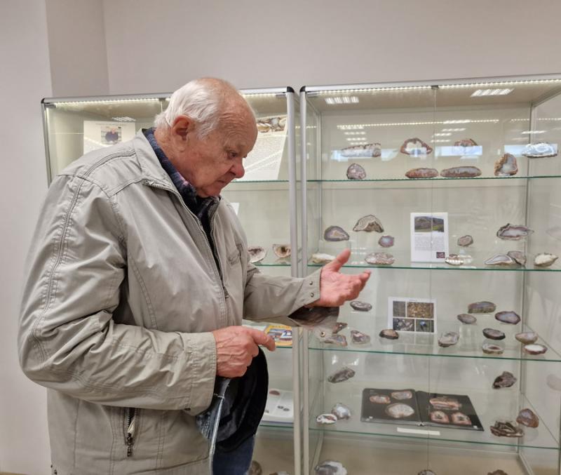 Kolekcininkas Vykintas Matuzevičius Mineralų muziejuje prie dovanotų agatų ir mineralų ekspozicijų