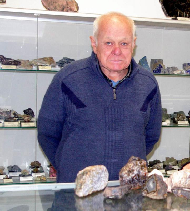 Kolekcininkas Vykintas Matuzevičius Mineralų muziejuje prie dovanotų agatų ir mineralų ekspozicijų